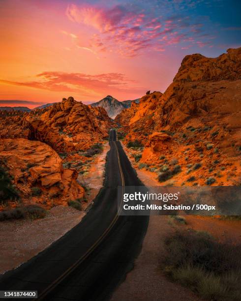 empty road leading towards mountains against sky during sunset,nevada,united states,usa - nevada foto e immagini stock