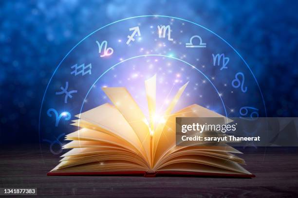 zodiac signs inside of horoscope circle. astrology in the many stars ancient book astrology and horoscopes concept - astrology stock pictures, royalty-free photos & images