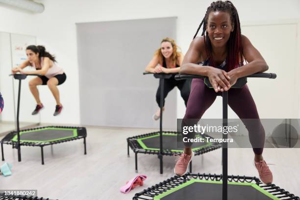 eine junge frau springt schnell auf einem fitness-trampolin. - trampoline stock-fotos und bilder