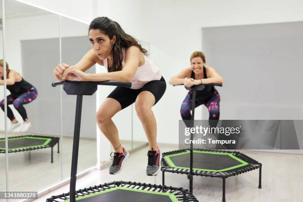 eine junge frau springt schnell auf einem fitness-trampolin. - trampolin stock-fotos und bilder