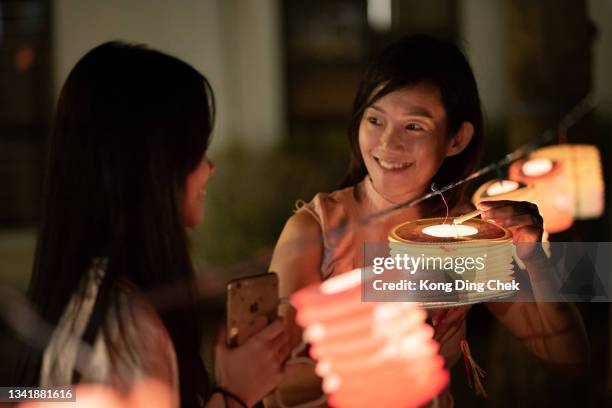 asian chinese mother and daughter light up candle in the paper lantern, celebration mid autumn festival. - girl full moon stockfoto's en -beelden