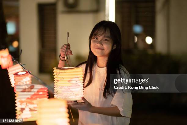 アジアの中国のティーンエイジャーの女の子は楽しんで、紙の提灯を見せて、お祝いの真秋の祭り。 - cap go meh ストックフォトと画像