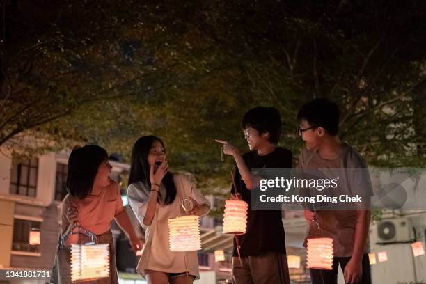 アジアの中国の兄弟といとこは、紙の提灯を持って、お祝いの中秋祭り。 - 中秋節 ストックフォトと画像