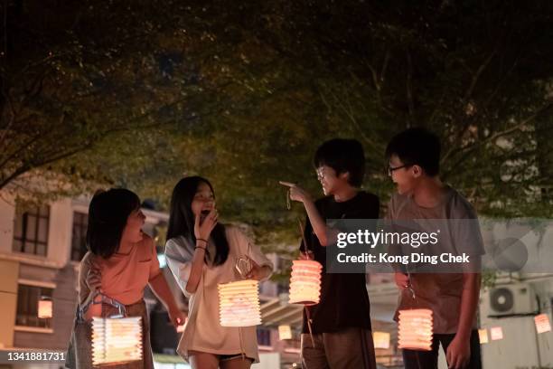 asian chinese sibling and cousin  holding paper lantern, celebration mid autumn festival. - chinese lantern festival stock pictures, royalty-free photos & images