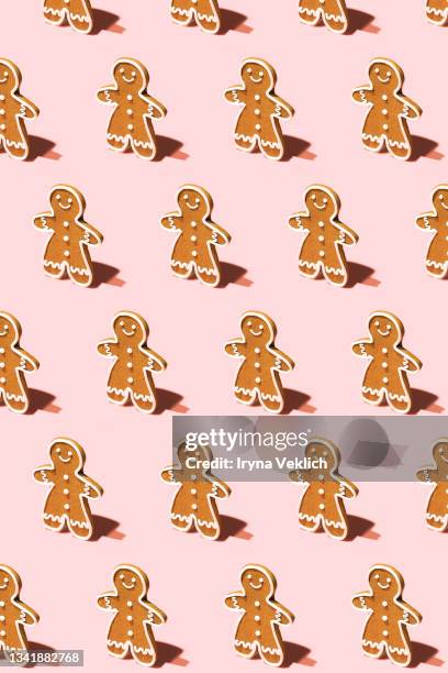 pattern made of gingerbread man on pastel pink background. - gingerbread cake stock pictures, royalty-free photos & images