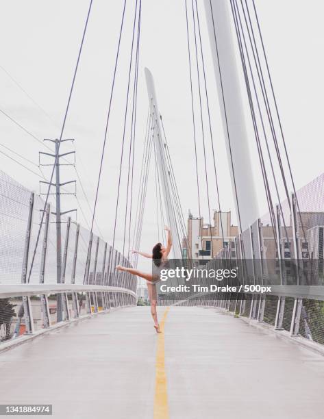 a woman is dancing on a suspension bridge,dallas,texas,united states,usa - drake one dance stock-fotos und bilder