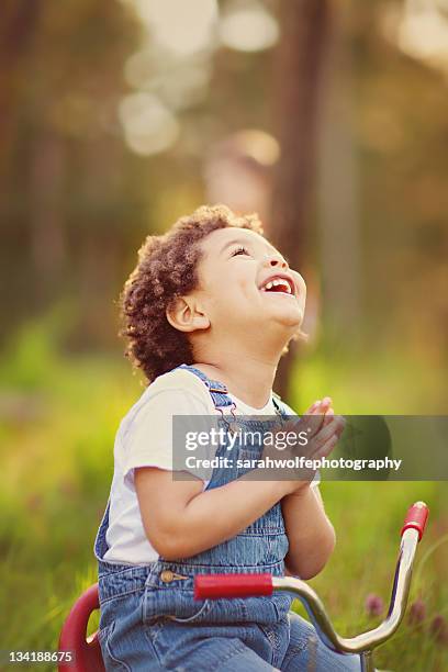 happy child looking up with hands in praying pose - child praying stock pictures, royalty-free photos & images