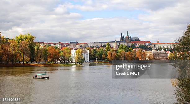 Prague Castle and the Vltava River can be seen in an autumn background.