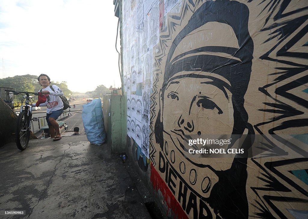 People walk past a wall with a caricatur