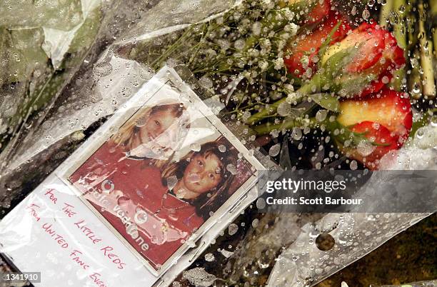 Photograph and flowers in remembrance of Jessica Chapman and Holly Wells lie on the ground August 18, 2002 outside St Andrew's Church in Soham,...
