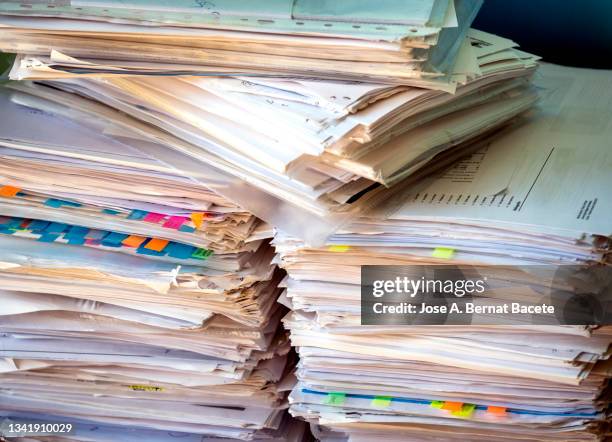 pile of papers and folders on a work table. - burocrazia foto e immagini stock
