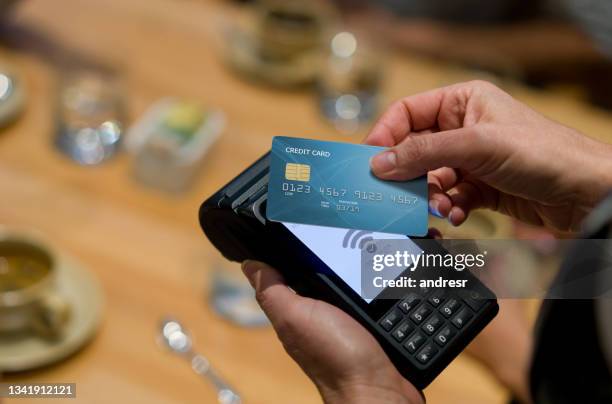 close-up on a customer at a restaurant making a contactless payment - tikken en betalen stockfoto's en -beelden