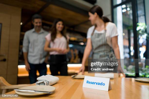 hostess showing couple to their table at a restaurant - reserved sign stock pictures, royalty-free photos & images