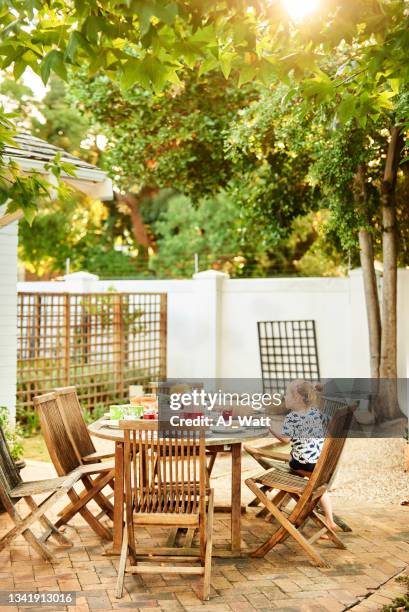 little boy sitting at a patio table full of food for lunch - memorial garden stock pictures, royalty-free photos & images