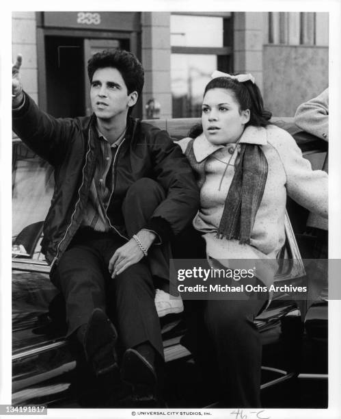 Bobbie Di Cicco and Wendie Jo Sperber on sitting on the hood of a car together in a scene from the film 'I Want To Hold Your Hand', 1978.