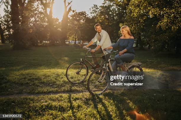 cycling through the sunny park - couple cycling bildbanksfoton och bilder