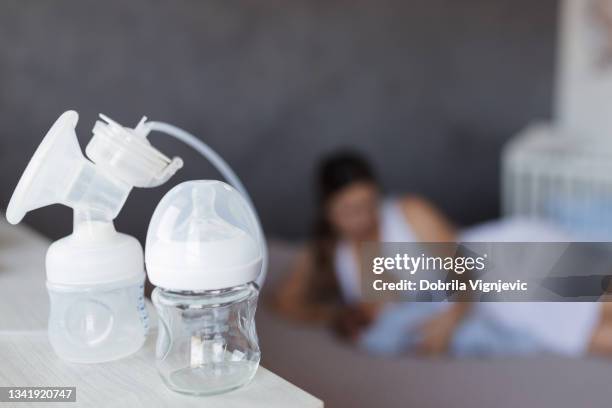breast pump attached to a baby bottle - lactating women stock pictures, royalty-free photos & images