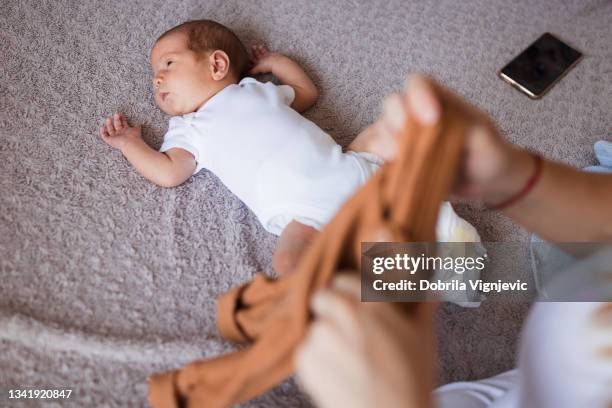 neugeborenes baby liegt mit einem smartphone auf dem bett - legacy do not correct stock-fotos und bilder