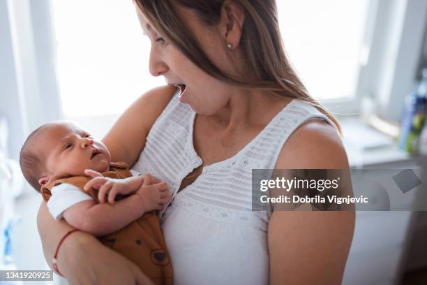 woman singing lullaby to an infant boy - lullaby stock pictures, royalty-free photos & images