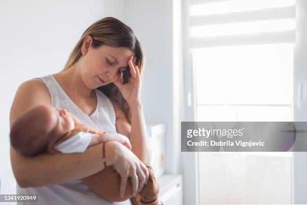 woman with post partum depression putting newborn baby to sleep - employment and labour 個照片及圖片檔