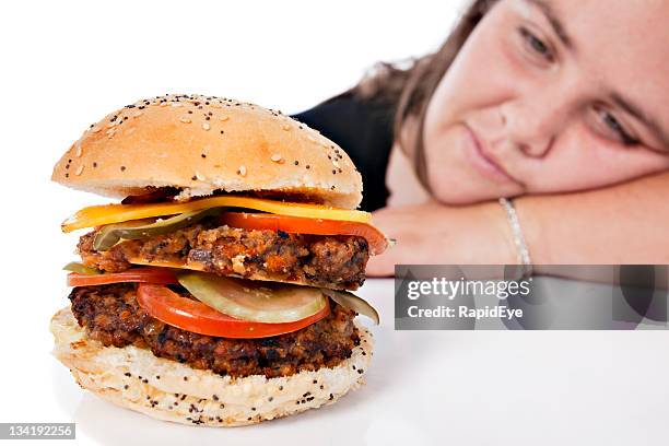 plump young woman gazes sadly at close-up cheeseburger - meat forbidden stock pictures, royalty-free photos & images