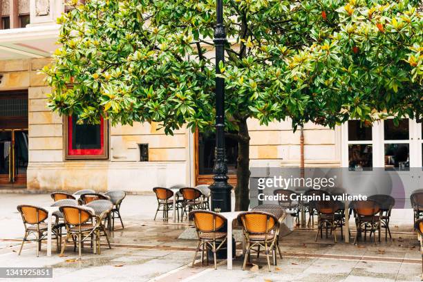 cafe terrace with empty tables on a pedestrian street in the city - pavement cafe imagens e fotografias de stock