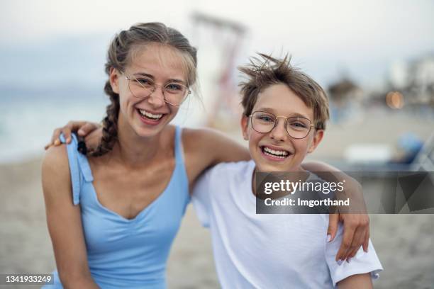 hermano y hermana abrazados en la playa - hermano hermana fotografías e imágenes de stock