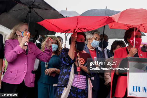 Rep. Sheila Jackson Lee holds onto her umbrella as it rains during a news conference on the treatment of Haitian immigrants at the U.S. Border in...