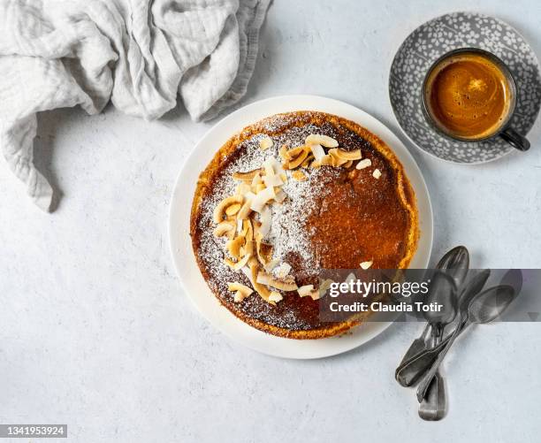 whole cake on a plate, and a cup of coffee on white background - coffee cake stockfoto's en -beelden