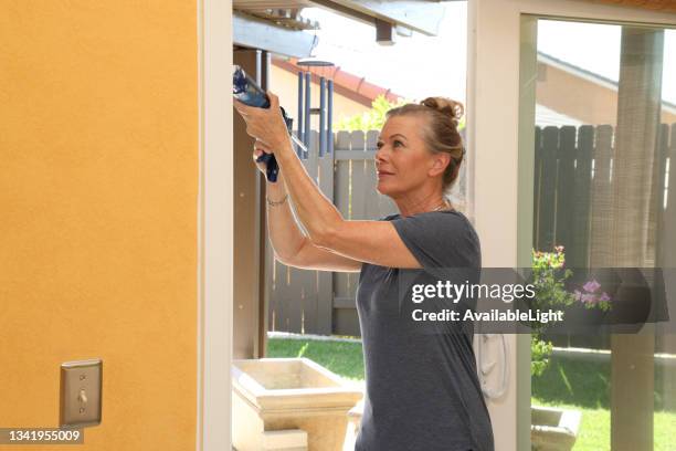 caulking gun woman horizontal - caulk stock pictures, royalty-free photos & images