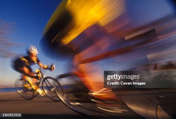 two road cyclists race by on a turn on the seattle waterfront in washington. - front de mer photos et images de collection