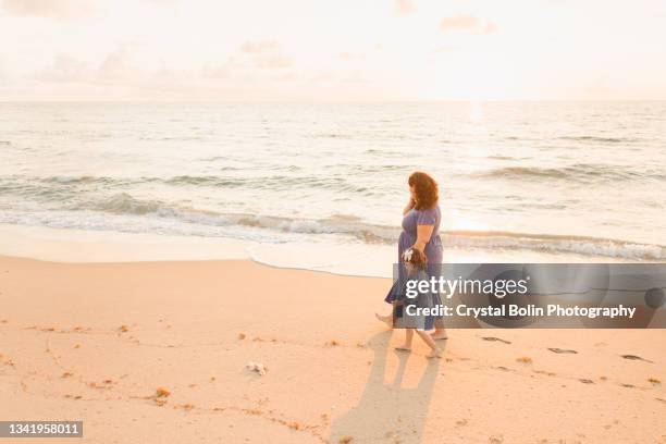 a 30-year-old pregnant mother & 2-year-old daughter enjoying a quiet golden beach sunrise in palm beach, florida in september of 2021 - west palm beach coast stock pictures, royalty-free photos & images