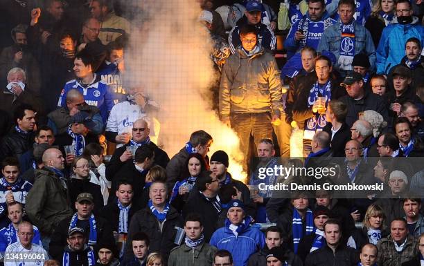 Supporters of Schalke ignite fireworks while Clemens Toennies , chairman of Schalke looks on during the Bundesliga match between Borussia Dortmund...