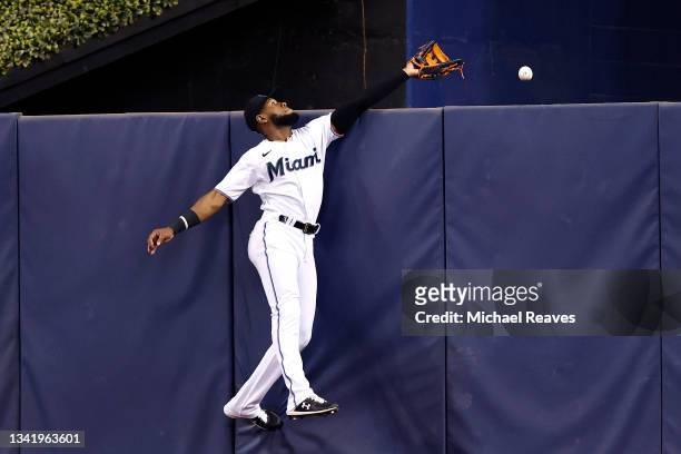 Bryan De La Cruz of the Miami Marlins can't reach a solo home run hit by Yadiel Hernandez of the Washington Nationals during the second inning at...