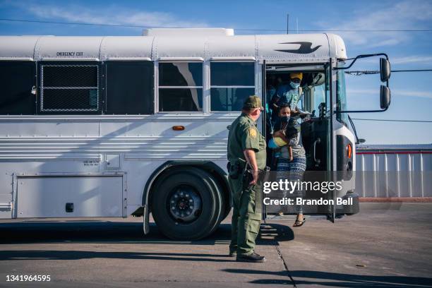 Migrants exit a Border Patrol bus and prepare to be received by the Val Verde Humanitarian Coalition after crossing the Rio Grande on September 22,...