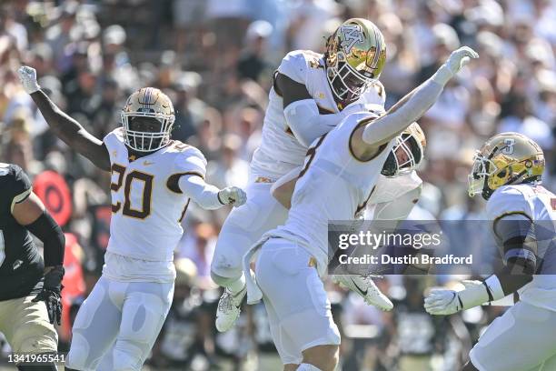 Defensive lineman Thomas Rush of the Minnesota Golden Gophers celebrates with teammates linebacker Donald Willis, defensive lineman Boye Mafe, and MJ...