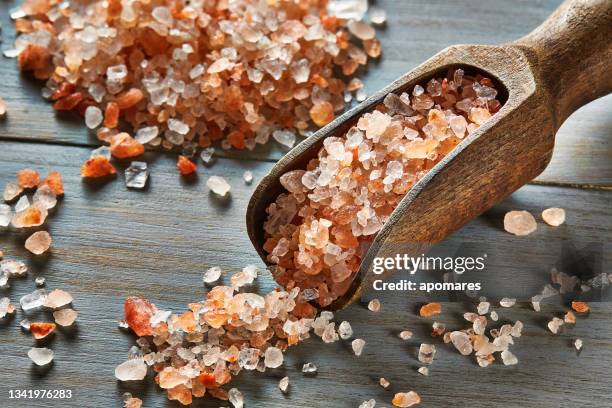 hölzerne portionsschaufel gefüllt mit himalaya-salz - himalayan salt stock-fotos und bilder