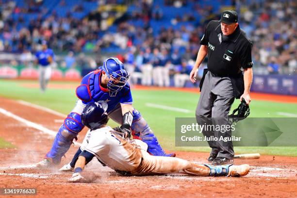 Alejandro Kirk of the Toronto Blue Jays tags Kevin Kiermaier of the Tampa Bay Rays out at home plate while dropping a note from his arm pad during...