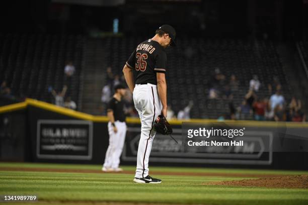Tyler Clippard of the Arizona Diamondbacks reacts after giving up a two-run home run to Freddie Freeman of the Atlanta Braves during the ninth inning...