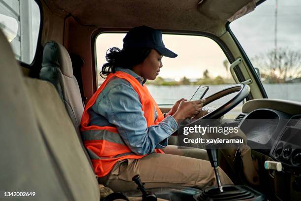 black truck driver in mid 20s checking smart phone - 25 years stock pictures, royalty-free photos & images