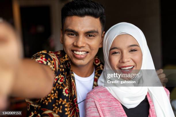 happy young muslim couple taking selfie together at home - malay lover stock pictures, royalty-free photos & images
