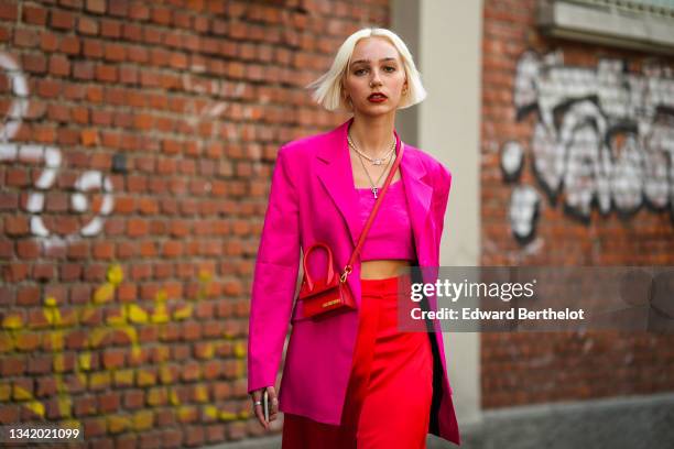 Guest wears a silver piercing, silver earrings, a pearls with a silver pendant necklace, a silver chain pendant Gucci necklace, a neon pink fluffy...