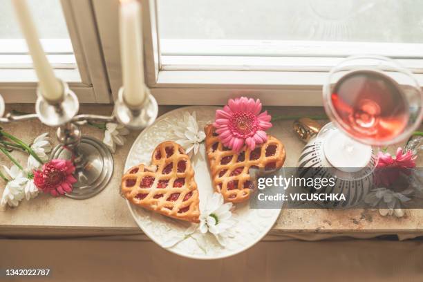 two hearts cakes and flowers on windowsill. top view. - homemade valentine stock pictures, royalty-free photos & images