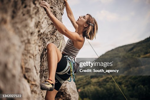 Joven escalando en roca en el acantilado Joven escalando en roca en el acantilado