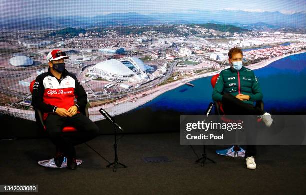 Kimi Raikkonen of Finland and Alfa Romeo Racing and Sebastian Vettel of Germany and Aston Martin F1 Team talk in the Drivers Press Conference during...