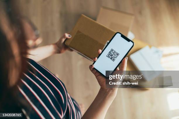 asian woman scanning qr code of parcel - coming home stock pictures, royalty-free photos & images