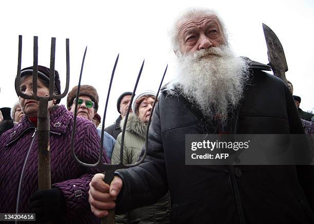 Elderly protesters hold pitchforks and spades during rally in front of the city's administration building in Donetsk on November 28, 2011. People...