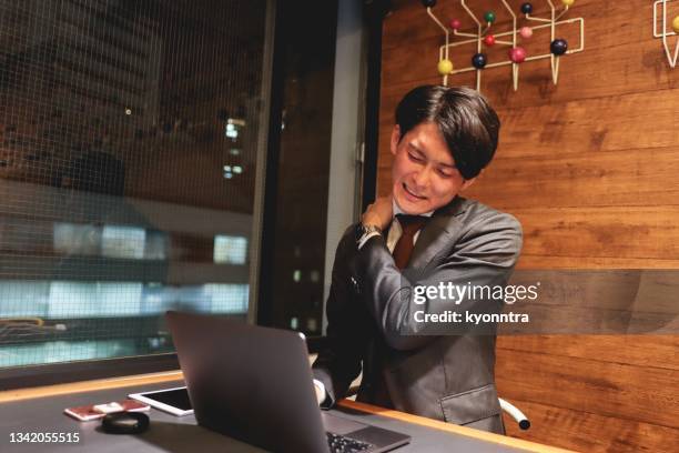 asian office worker working overtime - stijve schouder stockfoto's en -beelden