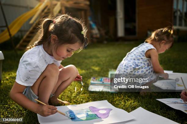 two girls drawing a picture in garden - art and craft stock pictures, royalty-free photos & images