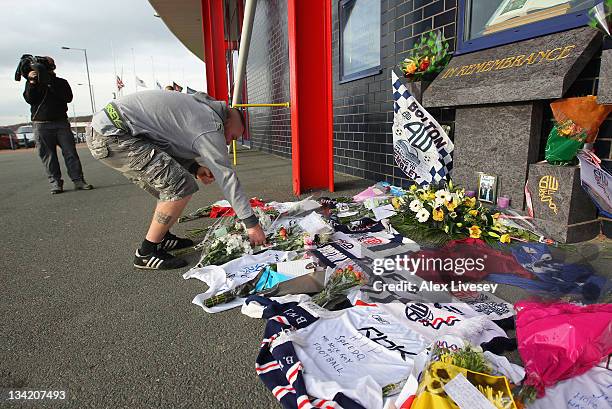 Supporter lays flowers amongst tributes to footballer and ex Bolton Wanderers player Gary Speed outside the Reebok Stadium the home ground of Bolton...